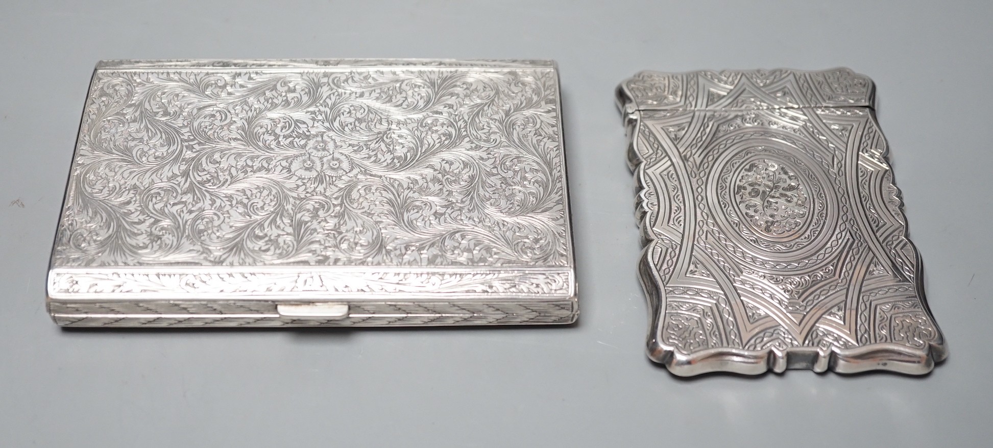 An engraved white metal card case, makers mark only AT, 97mm, together with an engraved 800 standard cigarette case, gross weight 8.9oz.